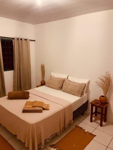 a bedroom with a large bed with towels on it at Casa Guiné in Goiás