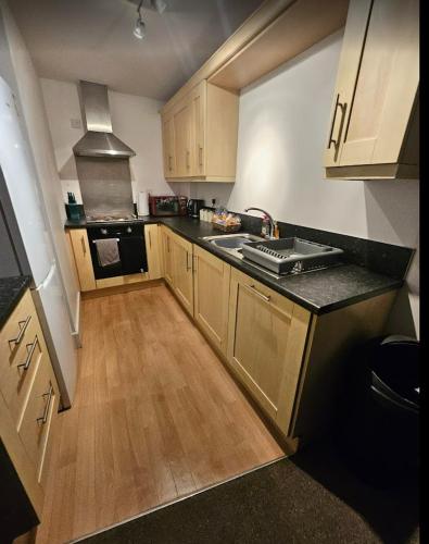 a small kitchen with a sink and a stove at Castle View Apartment, Cardiff City Centre in Cardiff