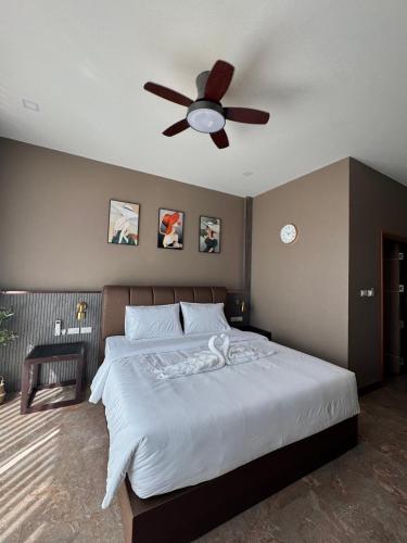 ein Schlafzimmer mit einem Bett mit Deckenventilator in der Unterkunft Me luxe hotel in Ban Chong Phli