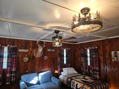 a bedroom with a bed and a couch and a ceiling fan at Bayview Campgrounds in Hillsboro