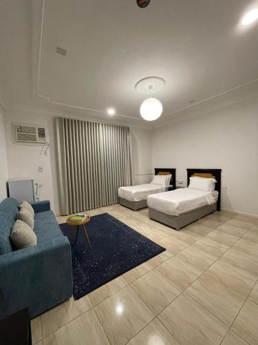een woonkamer met twee bedden en een bank bij كيان الين البديع in Abha