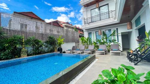 a swimming pool in front of a building with a house at The Center Point in Siem Reap