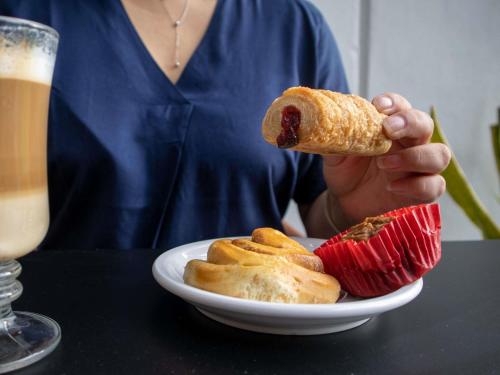 メリダにあるIbis Meridaのホットドッグと食べ物の皿を持っている人