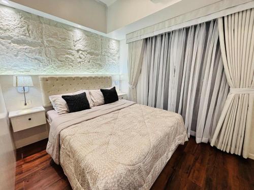 a bedroom with a bed and a large window at Condo Hotel Walking Abreeza Mall and Near SM Lanang in Davao City