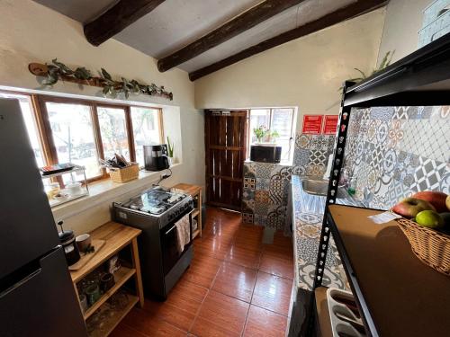 Il comprend une cuisine équipée d'un réfrigérateur et d'une cuisinière. four supérieur dans l'établissement Casa Paqocha Garden - Ollantaytambo - Hot Water - Wifi - Cocina Compartida, à Ollantaytambo