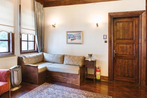 a living room with a couch and a wooden door at Uğurlu Konakları in Kastamonu