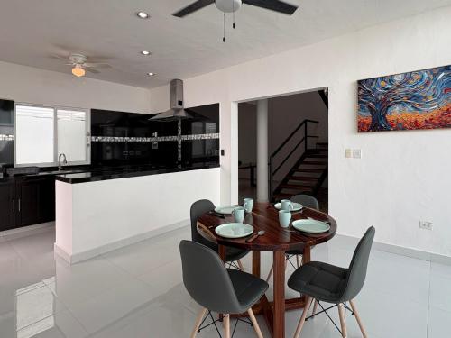 a kitchen and dining room with a wooden table and chairs at Vica Mayan Guest House - By Aloja RV in Mérida