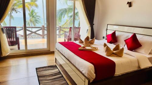 KappilにあるMaadathil Cottages & Beach Resortの海が見える大きなベッドのある寝室