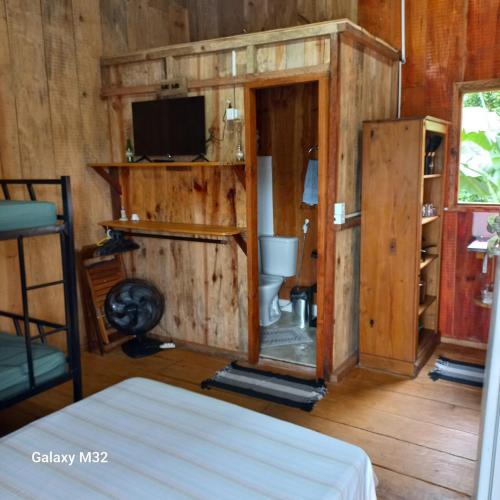 a room with a bathroom with a toilet and a tv at Chalés Vitória in Trindade