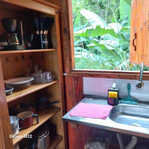 a kitchen with a sink and a window at Chalés Vitória in Trindade