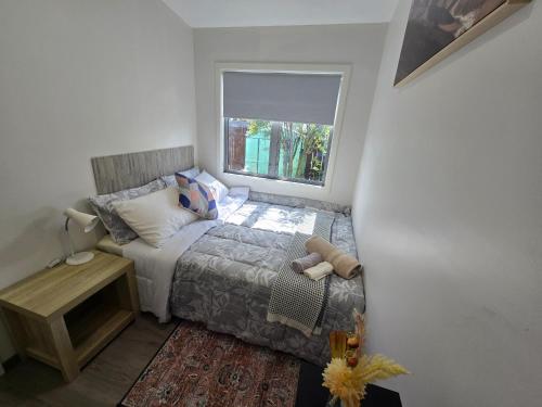 a small bedroom with a bed and a window at Manuki Tiny Retreat - Private stay Christchurch in Christchurch