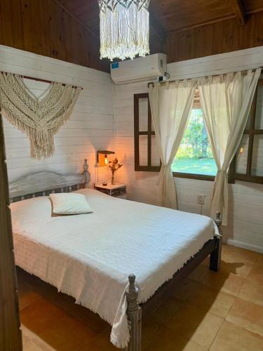 ein Schlafzimmer mit einem großen weißen Bett mit einem Kronleuchter in der Unterkunft Casa Nani in Ituzaingó