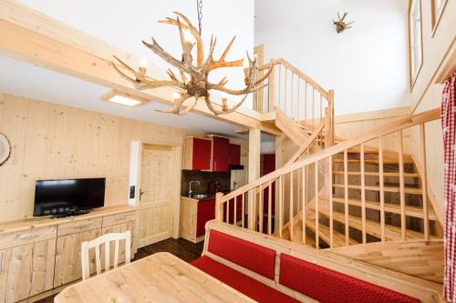 a living room with a staircase and a table and a chandelier at Ferienpark Gaal in Gaal