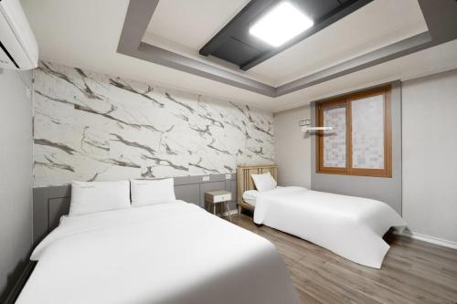 Ένα ή περισσότερα κρεβάτια σε δωμάτιο στο Yeosu Manhattan Hotel