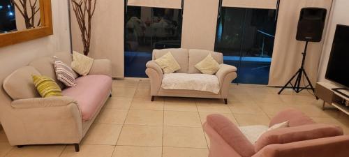 ein Wohnzimmer mit zwei Stühlen und einem Fernseher in der Unterkunft Tequesquitengo Finca Flor de Loto in Jojutla de Juárez