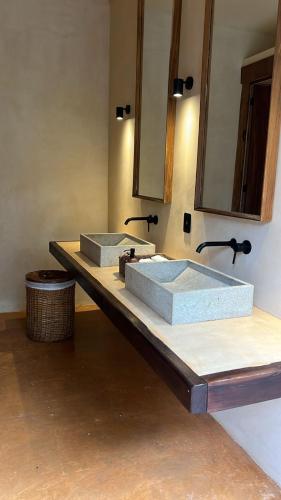a bathroom with two sinks and a mirror at Chic apartment in Aldea Mayab with Lagoon access and private splash pool in Xul-Ha
