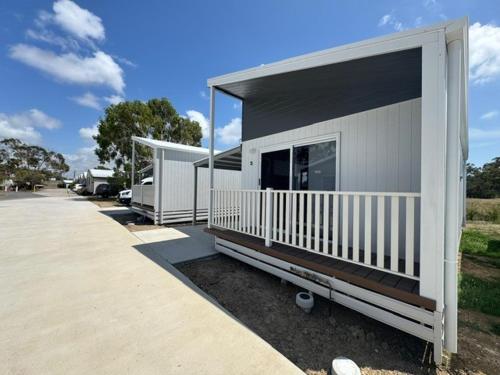 a small house with a porch and a driveway at Kin Kora Village in Gladstone