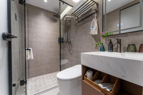a bathroom with a shower and a toilet and a sink at Bernard Hotel Putian Xinghuafu Historical and Cultural Street Branch in Putian