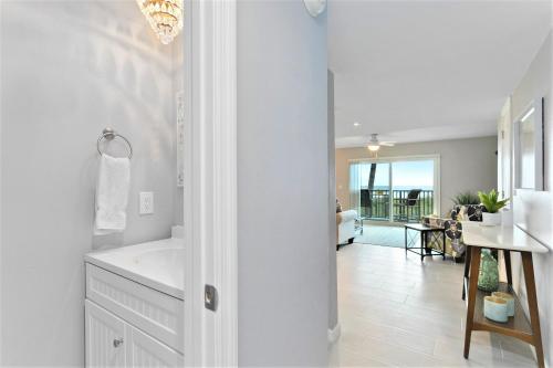 a white bathroom with a tub and a sink at Cocoa Beach Club in Cocoa Beach