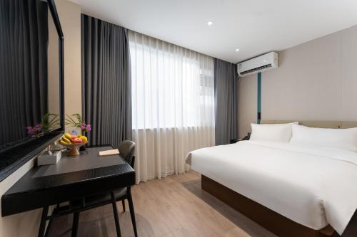 a hotel room with a bed and a desk at Bernard Hotel Putian Xinghuafu Historical and Cultural Street Branch in Putian