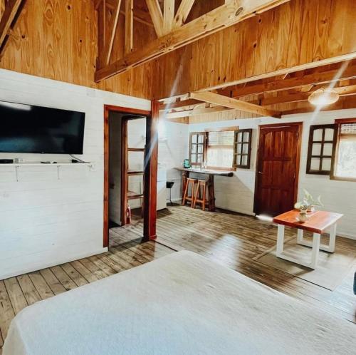 ein Schlafzimmer mit einem Bett und einem Fernseher in einem Zimmer in der Unterkunft Cabañas Parana Ranch in Ituzaingó