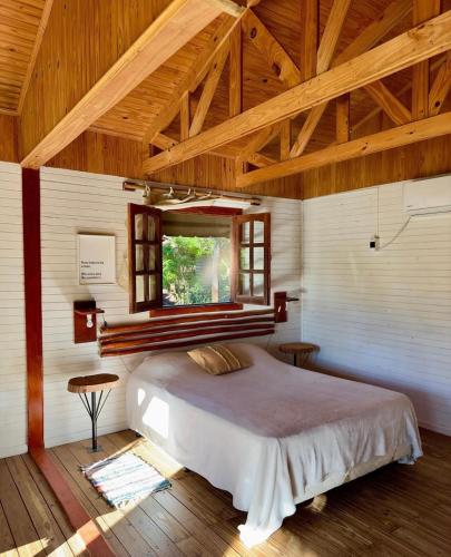 a bedroom with a large bed with a window at Cabañas Parana Ranch in Ituzaingó
