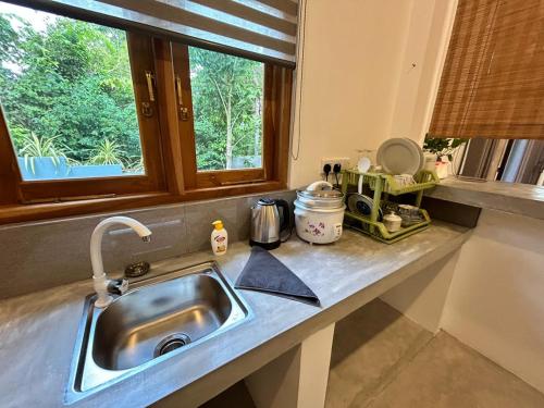 eine Küchentheke mit Spüle und Fenster in der Unterkunft Villa Tesh Hiriketiya in Dikwella