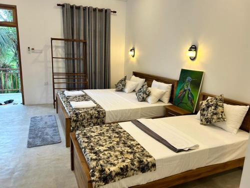 ein Hotelzimmer mit zwei Betten in einem Zimmer in der Unterkunft Villa Tesh Hiriketiya in Dikwella