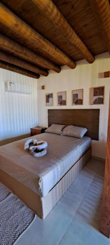 duże łóżko w sypialni z drewnianymi sufitami w obiekcie Flat Manaí 02 w mieście Maraú