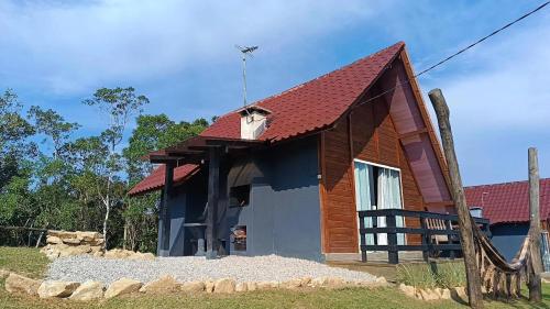 ein kleines Haus mit rotem Dach in der Unterkunft Chalés Refúgio nas montanhas in Guaratuba