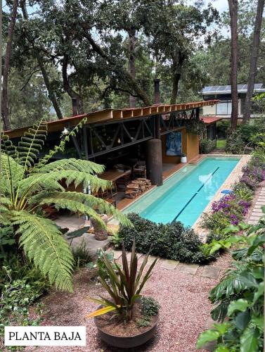 a house with a swimming pool in a garden at Pandurata Bed and Breakfast in Valle de Bravo