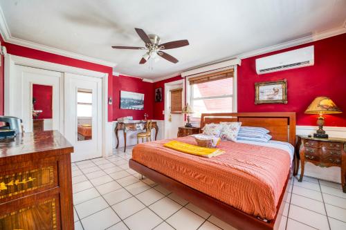 ein Schlafzimmer mit roten Wänden, einem Bett und einer Küche in der Unterkunft Sinclair Boutique Hotel in Hollywood