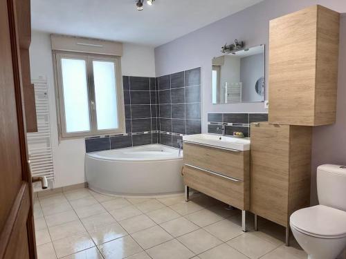 a bathroom with a tub and a sink and a toilet at Gîte de charme calme au cœur du Perche, proche Le Mans - FR-1-410-478 in Courgains