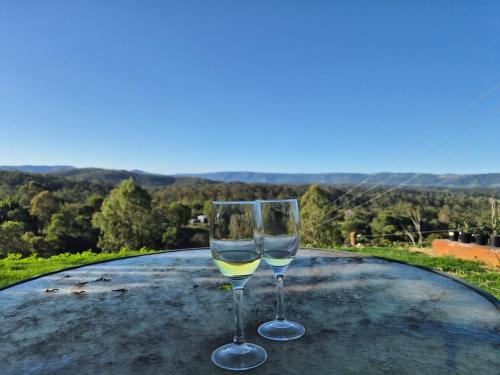 two glasses of white wine sitting on top of a table at Country Cottage of Yesteryear 