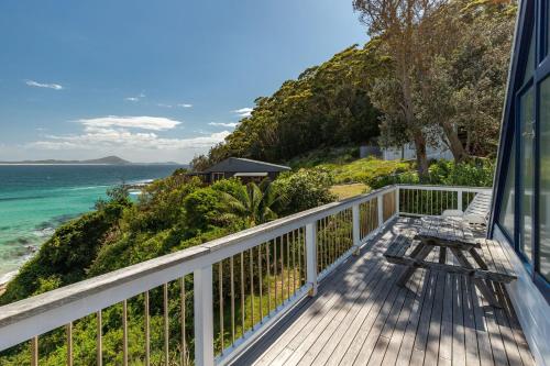 a balcony with a bench and the ocean at The Shack in Seal Rocks