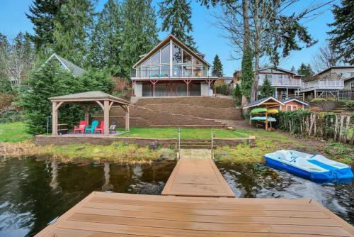 ein Haus auf dem Wasser mit einem Dock und einem Haus in der Unterkunft Lakefront Escape with Fire Pit and Views in McKees Beach