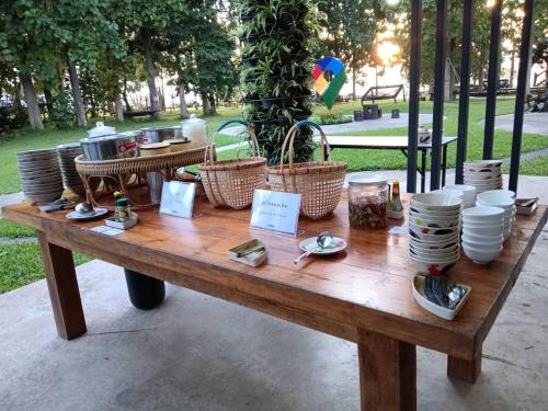 ein Holztisch mit Körben und Tellern darauf in der Unterkunft ห่มฟ้าโพธิ์แค้มป์ปิ้ง 