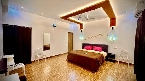 ein Schlafzimmer mit einem Bett mit roten Kissen darauf in der Unterkunft Villa 25 Eat-Sleep-Beach-Repeat in Kilpettai