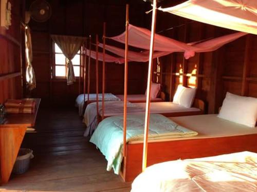 a group of beds in a room with a canopy at Mind House Bungalow in Nam Theun