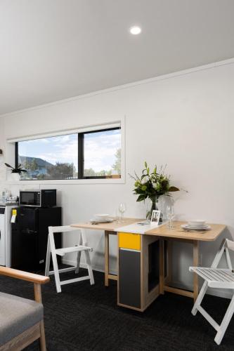 a room with a table and chairs and a kitchen at Studio Unit 5 Mins Walk to CBD in Gisborne