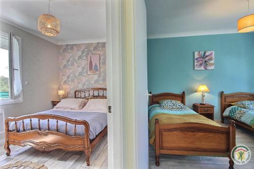 two beds in a bedroom with blue walls at Le jardin in Plestin-les-Grèves