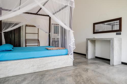 希克杜沃Villa Conch by Om的一间卧室配有一张带天蓬的蓝色床