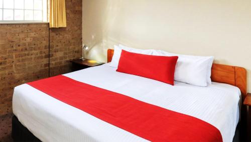 a red and white bed in a room at Ashton Motel in Tumut