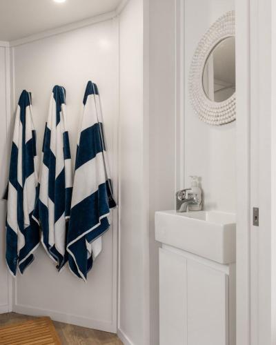 a bathroom with blue and white towels and a sink at Beachfront Studio Steps to the Sand in Gisborne