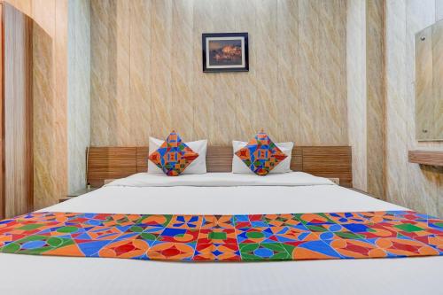 a bedroom with a bed with a colorful comforter at FabHotel Citi Residenci in Varanasi