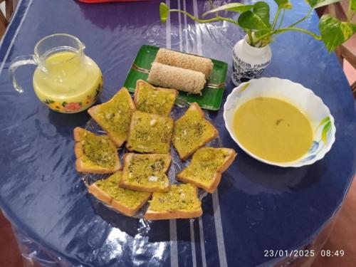 a blue table with a plate of toast and a bowl of soup at Srimali in Pelena