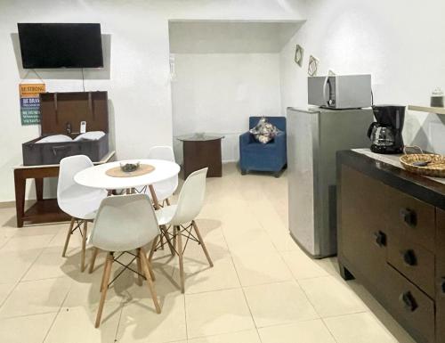 Una cocina con mesa y sillas y un refrigerador. en Departamento AAK, en Mérida
