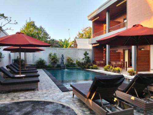 蓝梦岛C'man Guest House的房子旁边有带椅子和遮阳伞的游泳池