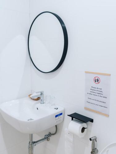 a bathroom with a sink and a mirror on the wall at Peaceful 2BR Home Walk to Halal Street Food in Hat Yai