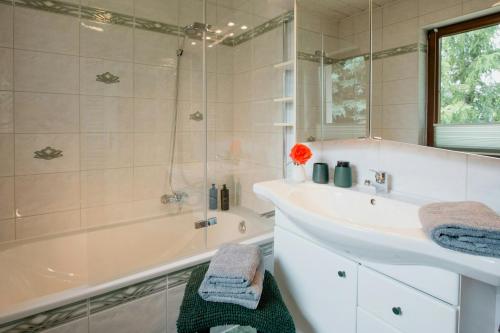 une salle de bain avec une baignoire, un lavabo et une douche dans l'établissement 1970S Architects House In The Countryside, à Rochlitz